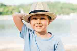 Foto gratuita muchacho sonriente en sombrero que disfruta de luz del sol