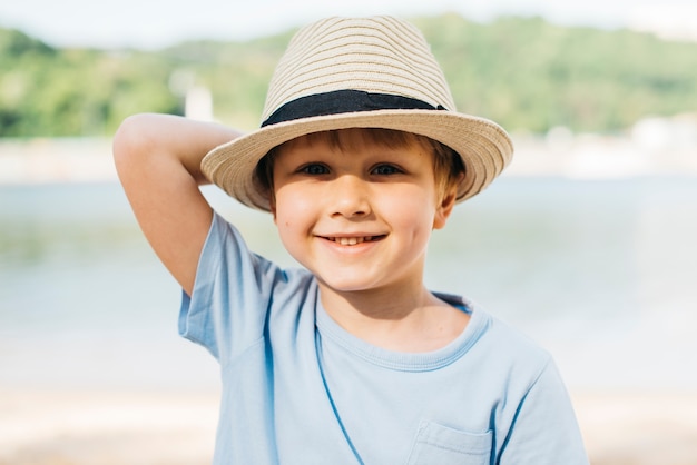 Muchacho sonriente en sombrero que disfruta de luz del sol