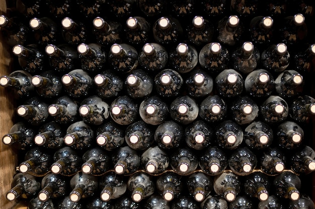 Muchas botellas de vino tinto en una bodega.