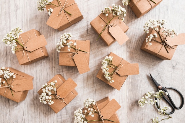 Muchas cajas de regalo de boda con tijera sobre fondo de madera