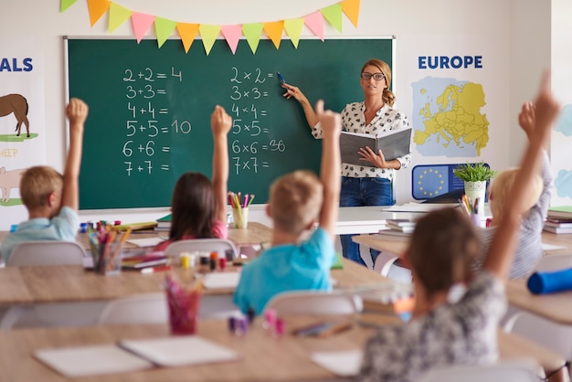 Muchas manos de voluntarios durante la clase de matemáticas.