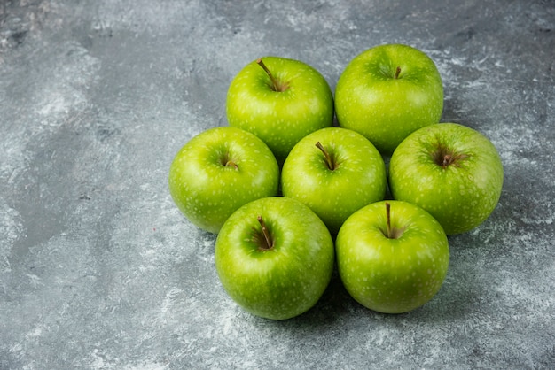 Muchas manzanas maduras sobre mármol.