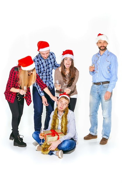 Muchas mujeres y hombres jóvenes bebiendo en la fiesta de Navidad sobre fondo blanco de estudio