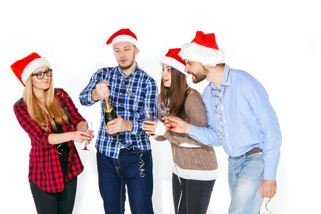 Muchas mujeres y hombres jóvenes bebiendo en la fiesta de Navidad sobre fondo blanco de estudio