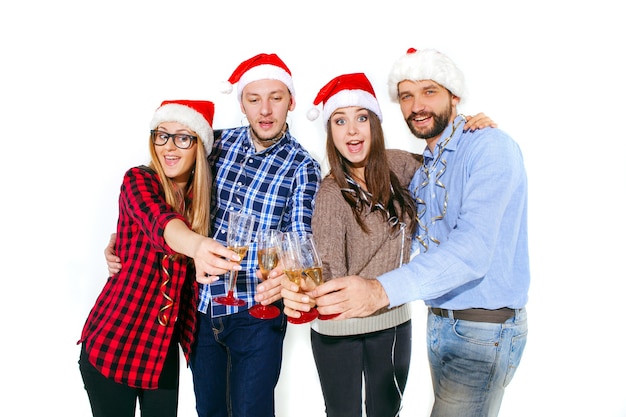 Muchas mujeres y hombres jóvenes bebiendo en la fiesta de Navidad sobre fondo blanco de estudio