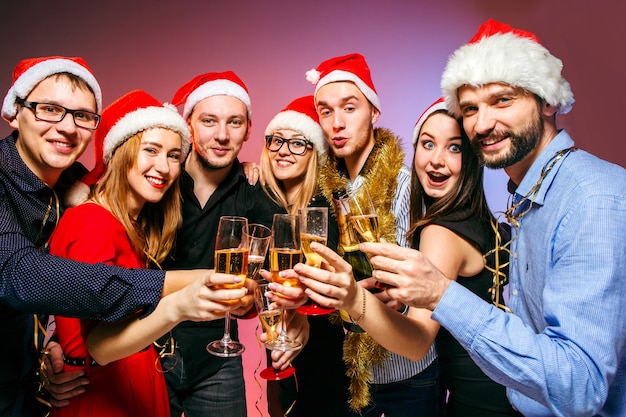 Muchas mujeres y hombres jóvenes bebiendo en la fiesta de Navidad