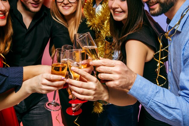 Muchas mujeres y hombres jóvenes bebiendo en la fiesta de navidad