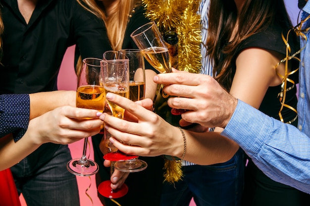 Muchas mujeres y hombres jóvenes bebiendo en la fiesta de navidad