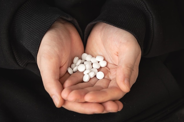 Foto gratuita muchas pastillas blancas en manos de un hombre adulto