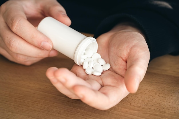 Foto gratuita muchas pastillas blancas en manos de un hombre adulto