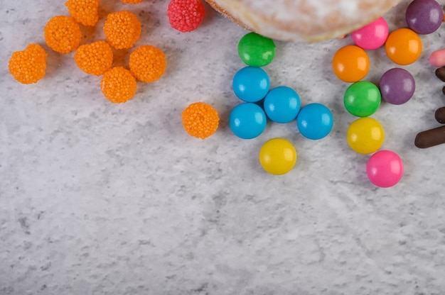 Mucho caramelos multicolores colocados sobre una superficie blanca.