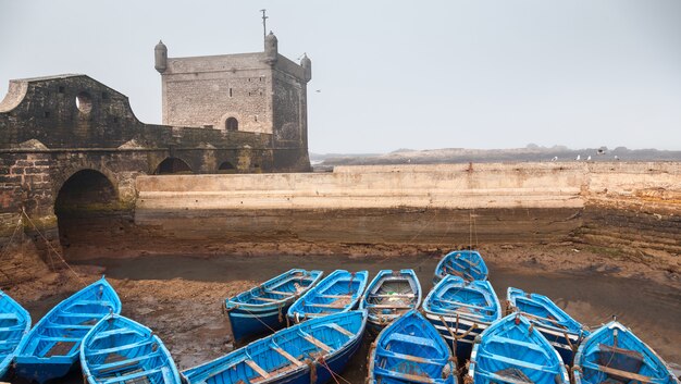 Muchos barcos de pesca vacíos azules atados al lado de otros