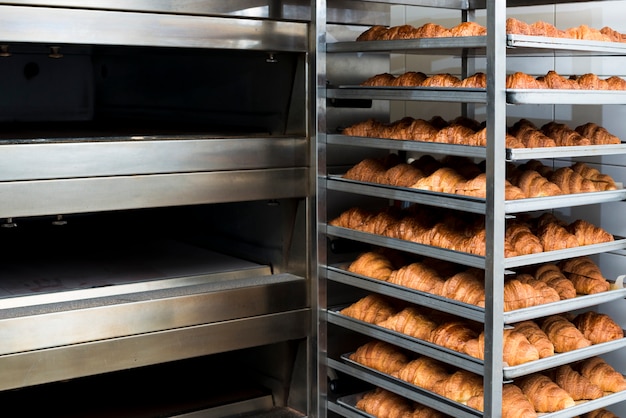 Muchos croissant recién horneado en un horno de panadería