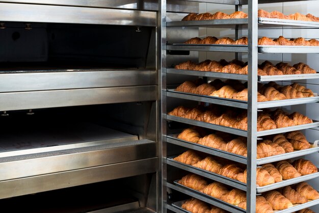 Muchos croissant recién horneado en un horno de panadería