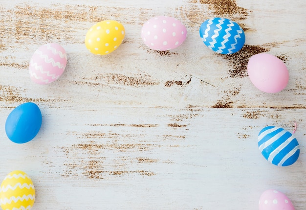 Muchos huevos de Pascua esparcidos en mesa de madera