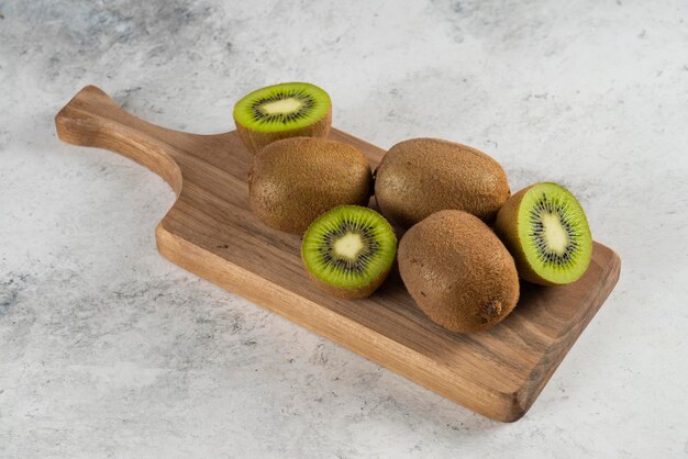 Muchos de los kiwis sobre tabla de madera.