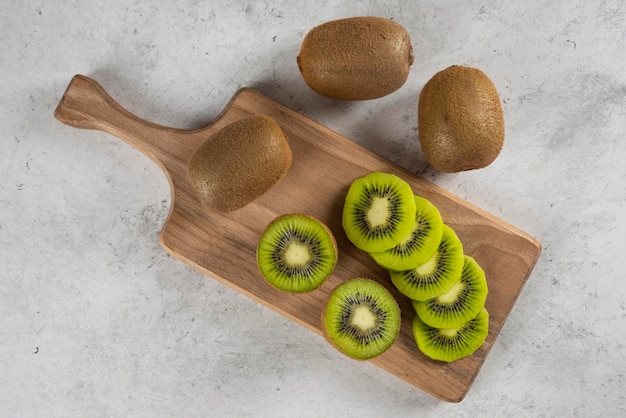 Muchos de los kiwis sobre tabla de madera.