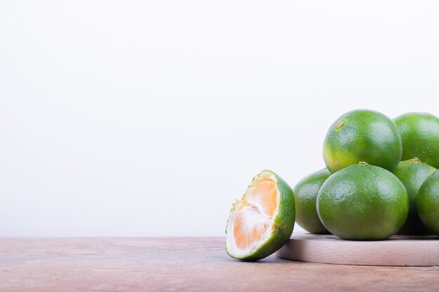 Muchos de mandarina verde sobre superficie de mármol.