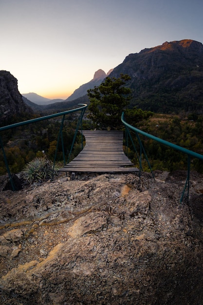 Foto gratuita muelle en el acantilado con la hermosa vista de las montañas.