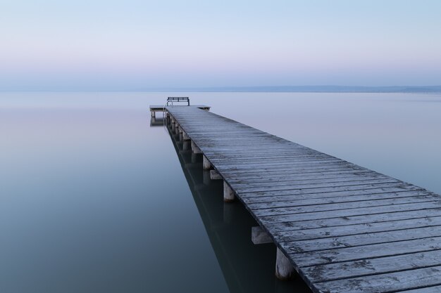 Muelle de madera en el mar bajo un cielo nublado en la noche