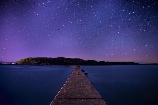 Muelle de madera marrón bajo el cielo nocturno