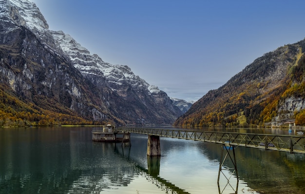 Foto gratuita muelle de madera marrón en el lago cerca de la montaña durante el día