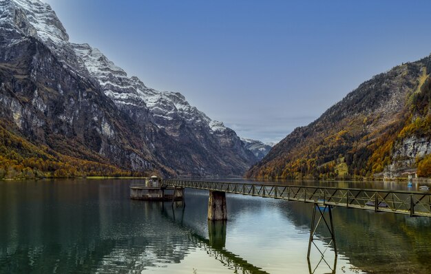 Muelle de madera marrón en el lago cerca de la montaña durante el día