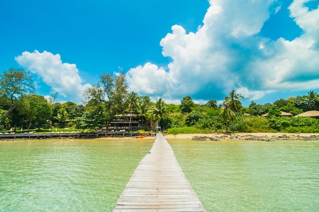 Muelle de madera o puente con playa tropical y mar en isla paradisíaca