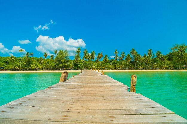 Muelle de madera o puente con playa tropical y mar en isla paradisíaca