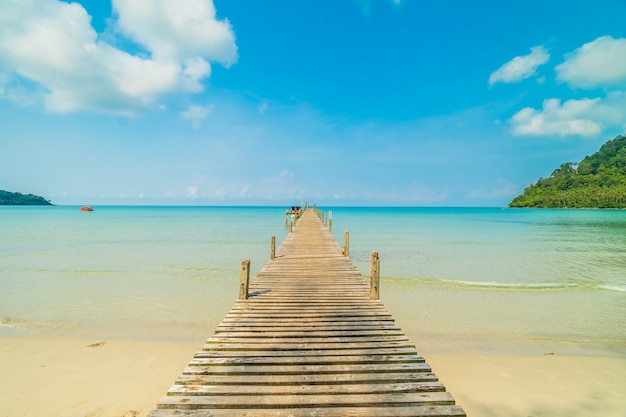 Muelle de madera o puente con playa tropical.