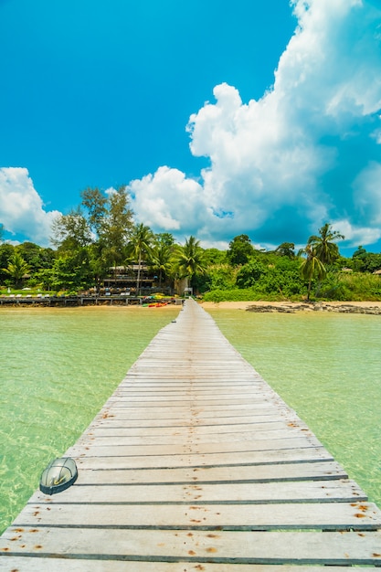 Muelle de madera o puente con playa tropical.