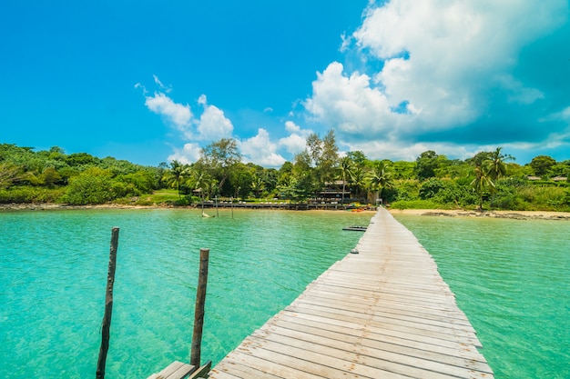 Muelle de madera o puente con playa tropical.