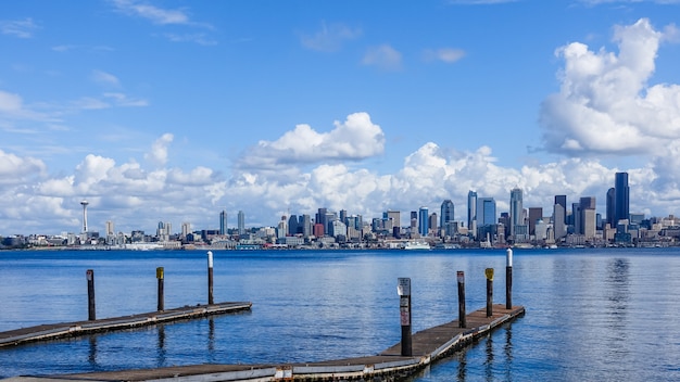 Muelle de madera sobre un mar con la ciudad de Seattle, Estados Unidos bajo las hermosas nubes