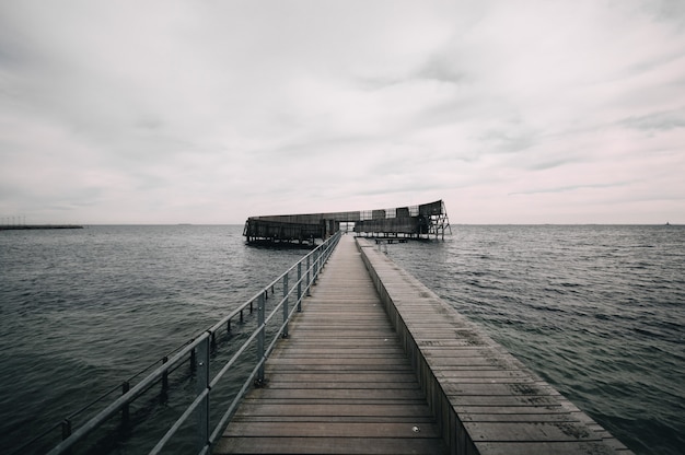 Muelle que conduce al océano bajo el cielo sombrío