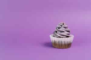 Foto gratuita muffin agradable sobre fondo violeta