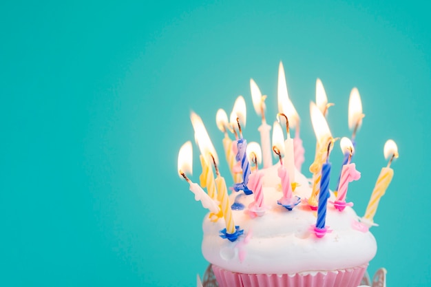 Muffin de cumpleaños delicioso con velas de colores