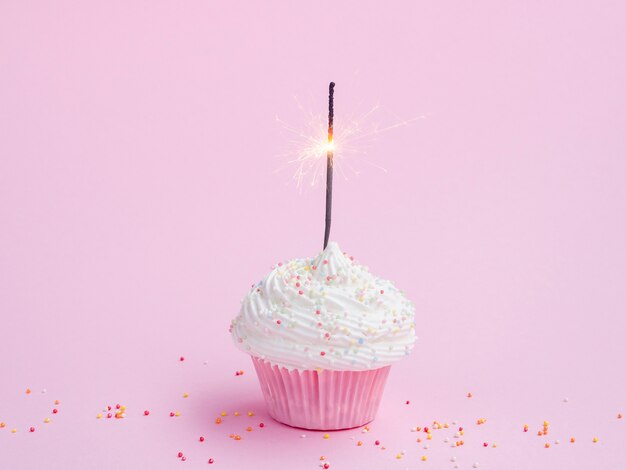 Muffin de cumpleaños sabroso sobre fondo rosa