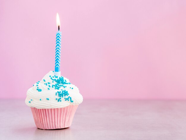 Muffin de cumpleaños sabroso con vela azul