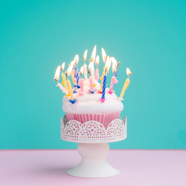 Muffin de cumpleaños sabroso con velas de colores