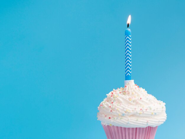 Muffin de cumpleaños sobre fondo azul.