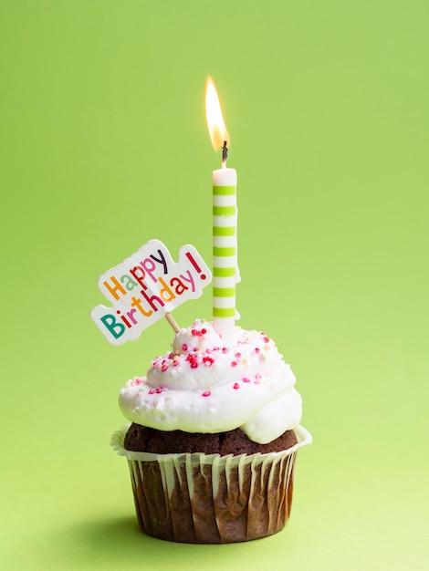 Muffin con vela y cartel de feliz cumpleaños