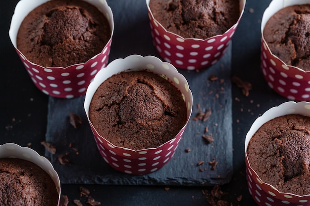 Muffins de chocolate apetitosos sabrosos en tazas.
