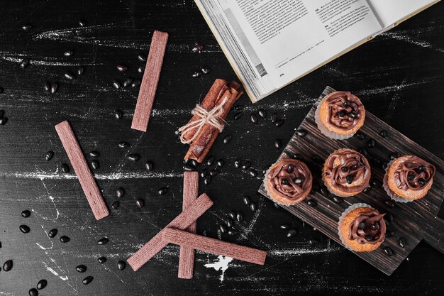 Foto gratuita muffins con crema de cacao sobre una tabla de madera