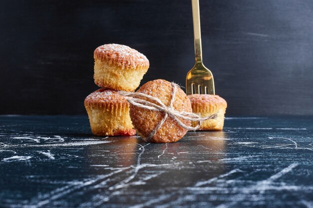 Muffins de vainilla aislados en superficie azul.