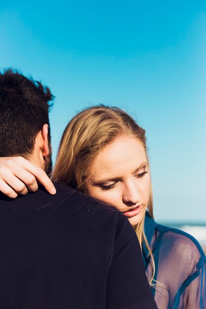 Mujer abrazando a hombre en la playa