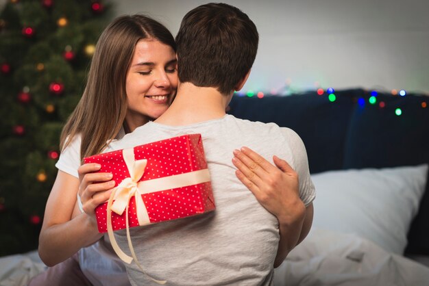Mujer abrazando a hombre para regalo de navidad