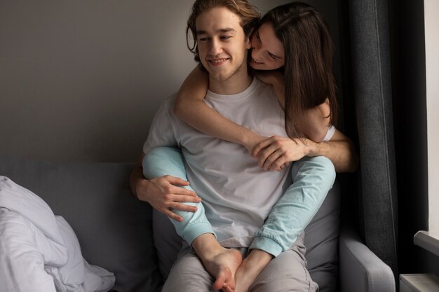 Mujer abrazando a hombre sonriente mientras cogidos de la mano