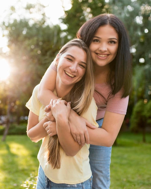 Mujer abrazando a su amiga por detrás