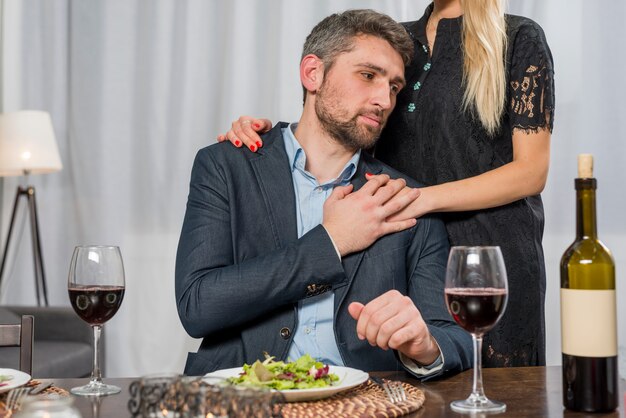 Mujer, abrazar, hombre, en la mesa, con, placa, y, anteojos