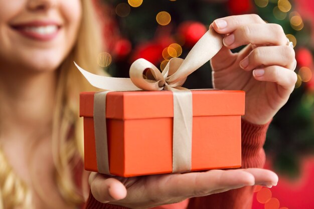 Mujer abriendo un regalo naranja